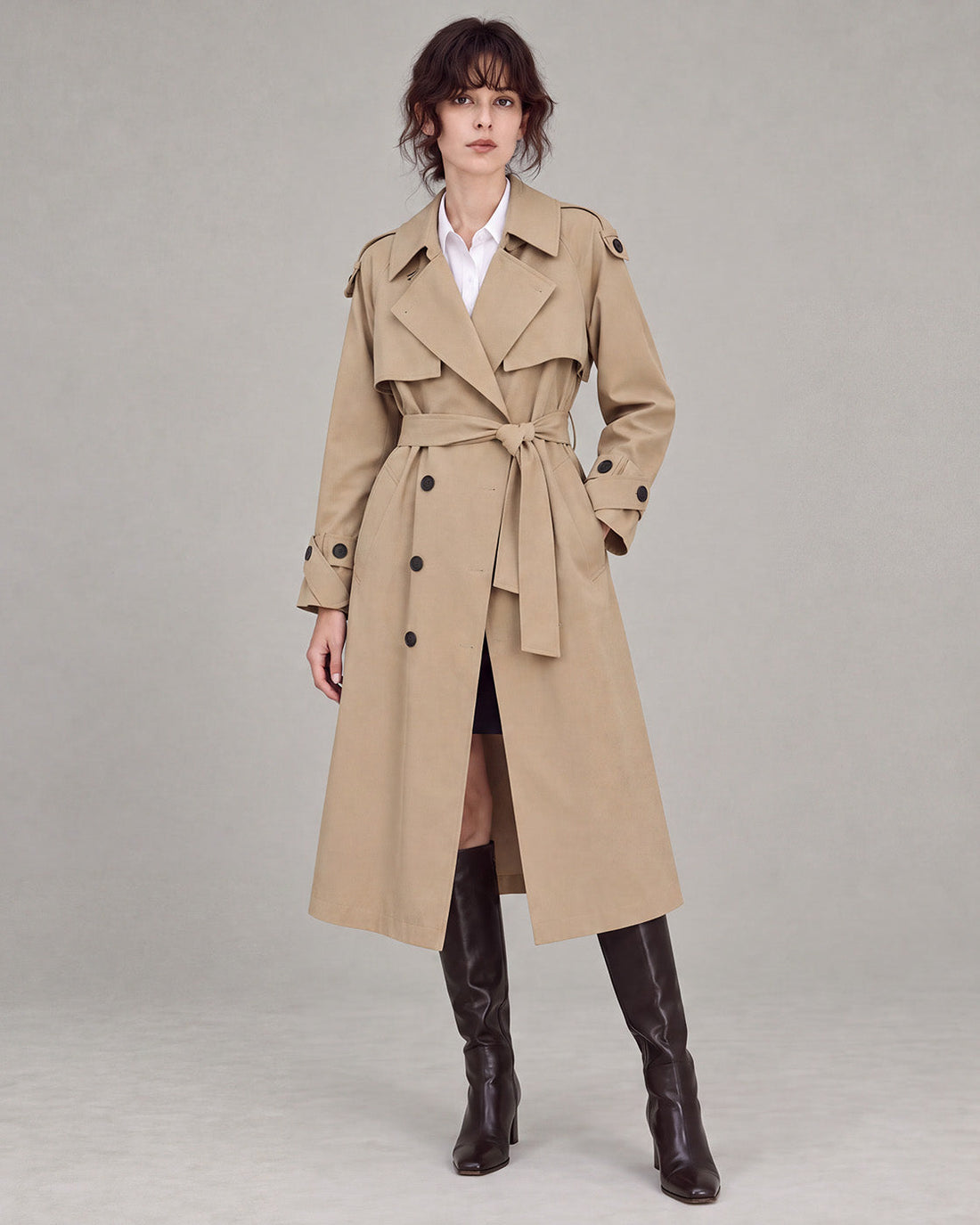 Khaki longline double-breasted trench coat with a self-tie belt.