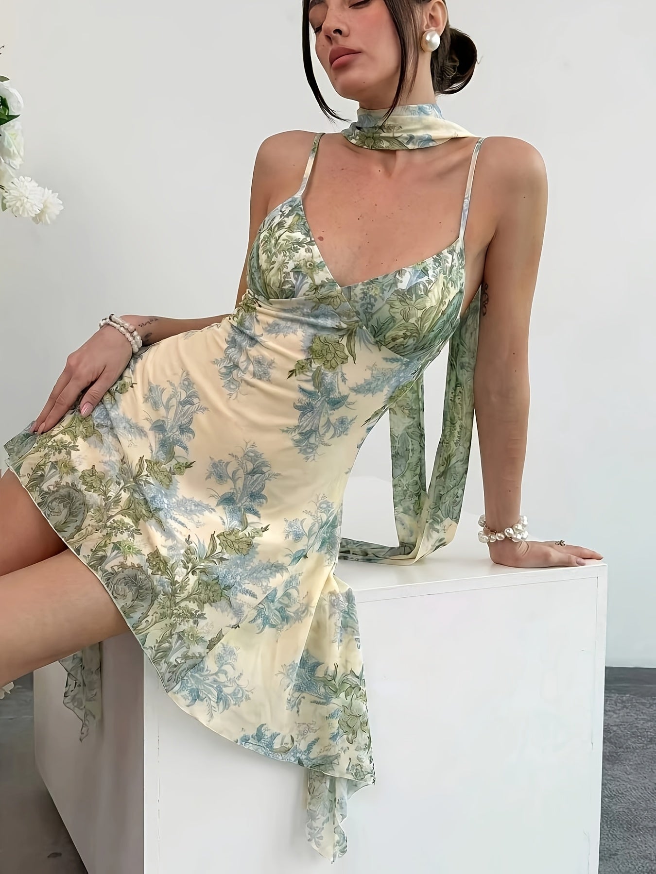 Multi-color printed tie-strap mini dress, seated three-quarter view