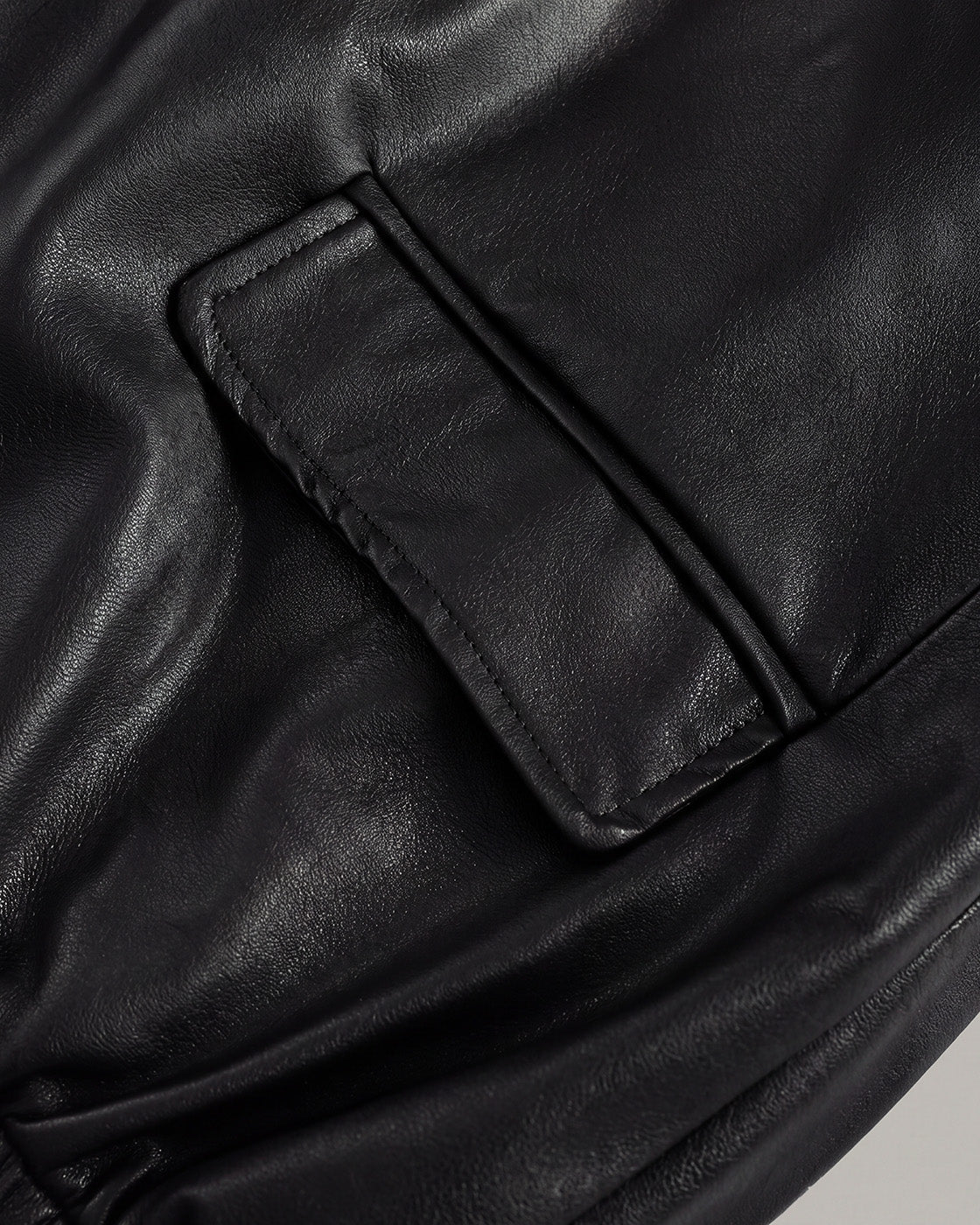 Relaxed Faux-Leather Zip Jacket in Black — detail pocket hem