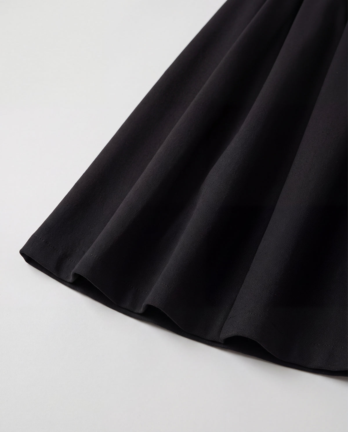 Wool-Look Pleated Midi Skirt — Black, hem detail