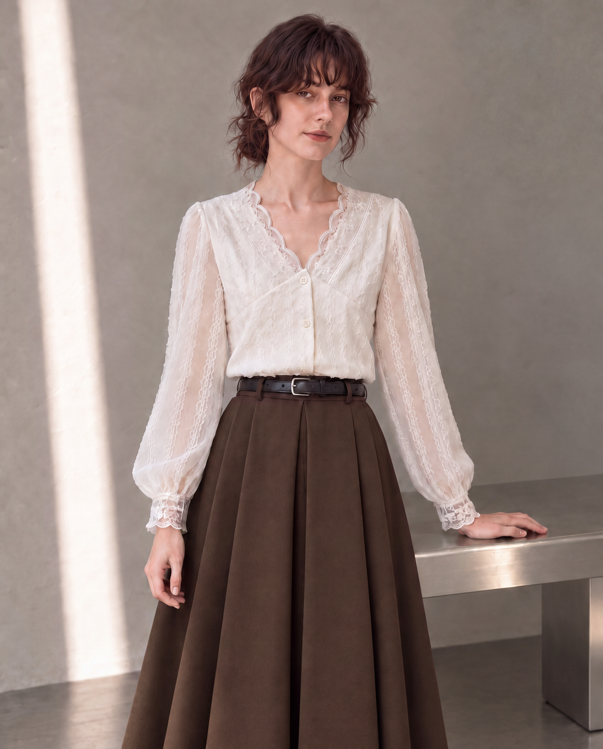 Workday Edit Look 01 – White lace-trim V-neck blouse 3244, upper-body front with Coffee Brown pleated midi skirt 8252 in the gray wall scene.